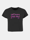 schwarzes Crop-Top, Vorderseite mit lila-rosa tropfender Schrift y'all have a great day und kleinem Smiley